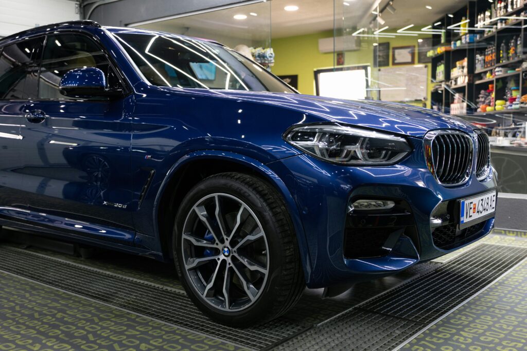 Detailed image of a luxury blue SUV parked in a modern garage with sleek design elements.